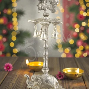 A beautiful 17.5 Inch Silver Plated Aluminium Elephant Peacock Diya stand with intricate details.