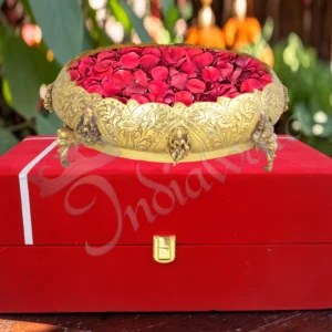 An 11 inch Gold Plated Brass Gifting Urli Pot filled with water and floating flowers.