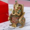 A beautifully handcrafted Brass Stone Work Gifting Ganesh Statue seated on a chair.